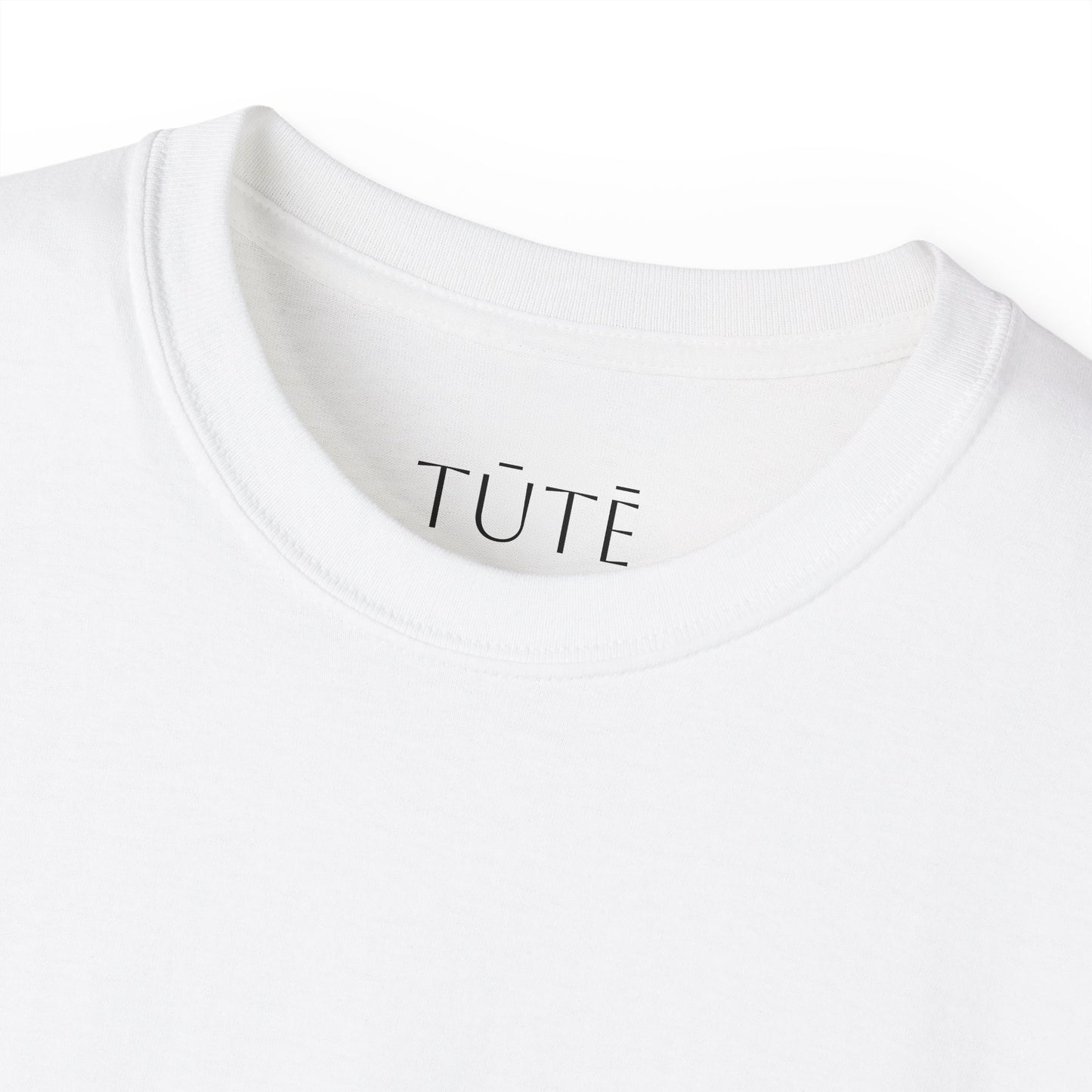 Close-up of a white shirt with 'TUTE' branding on a white background